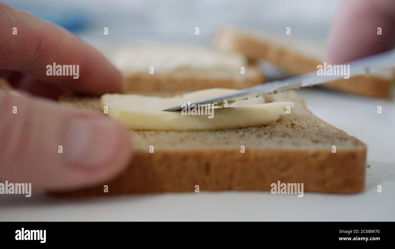 Petit déjeuner avec beurre sur le pain grillé, étaler la margarine sur une tranche de pain frais dans la cuisine Banque D'Images