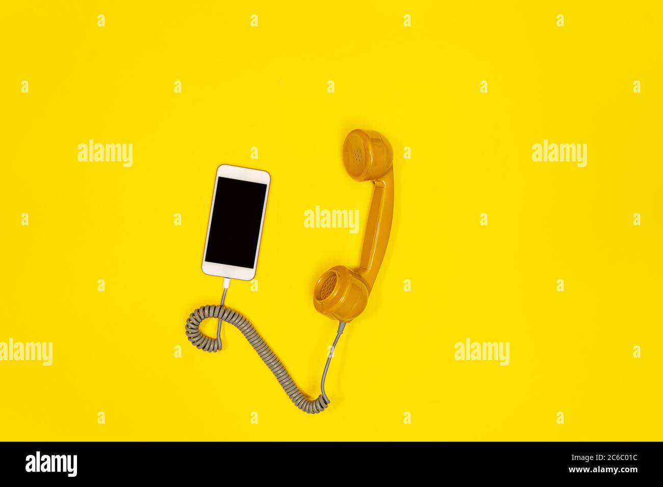 Téléphone portable et téléphone à l'ancienne sur fond jaune. Style rétro moderne. Nouvelle technologie ancienne. Banque D'Images