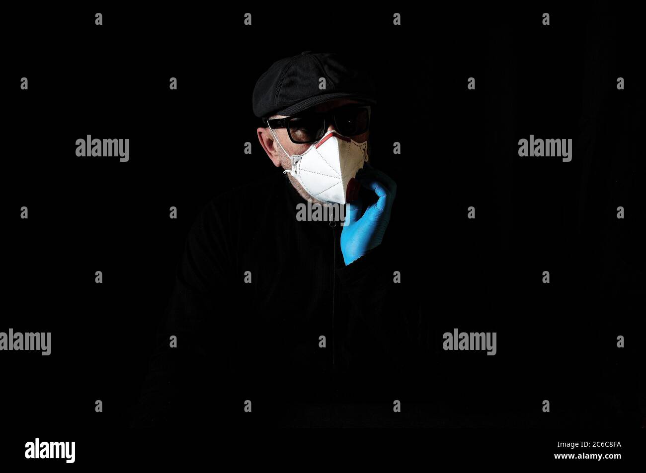 Homme âgé dans un respirateur et des gants pour la protection contre Covid-19 Banque D'Images