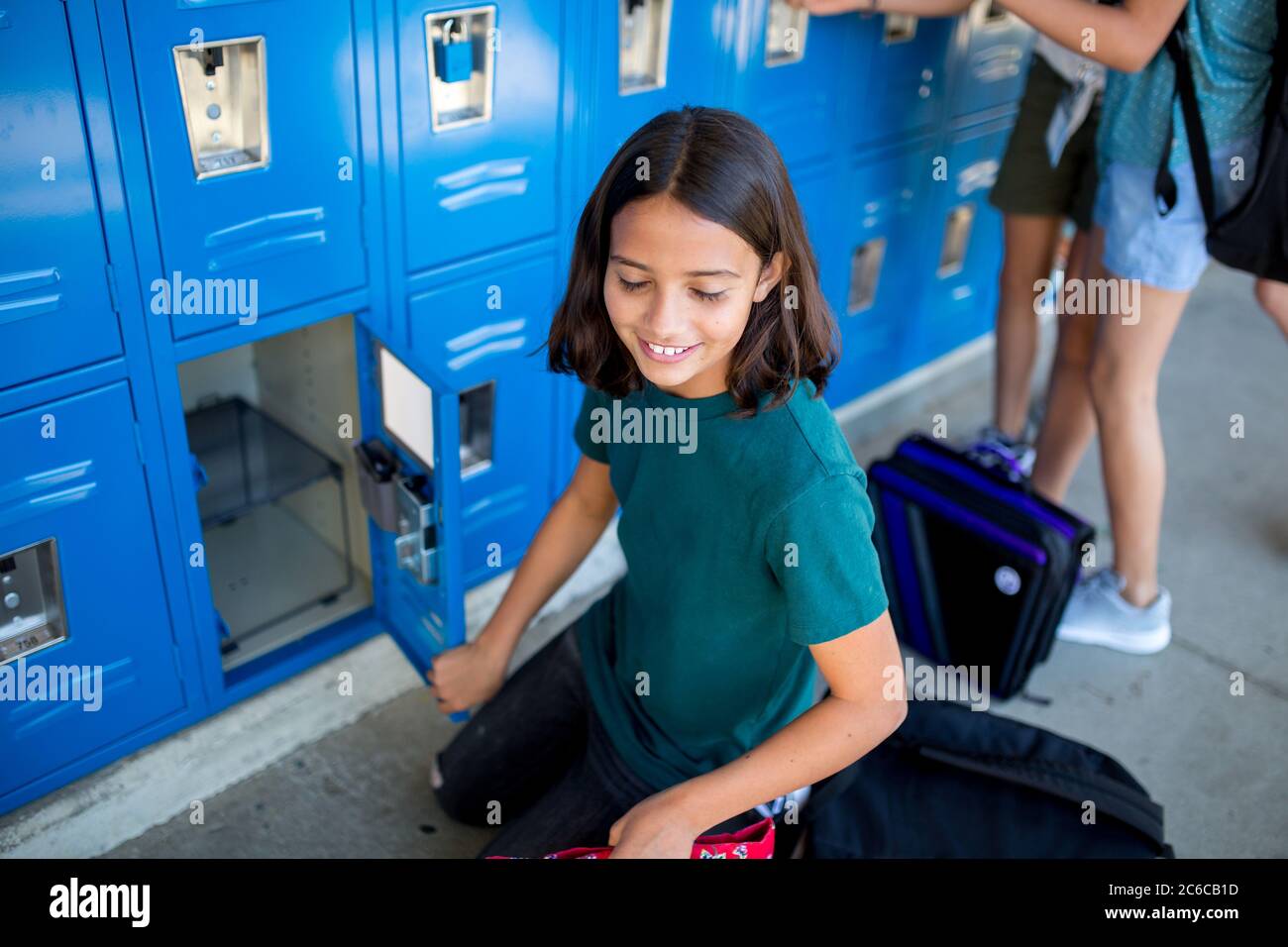 Tween fille sourit avec les yeux fermés après qu'elle l'a ouverte casier scolaire Banque D'Images