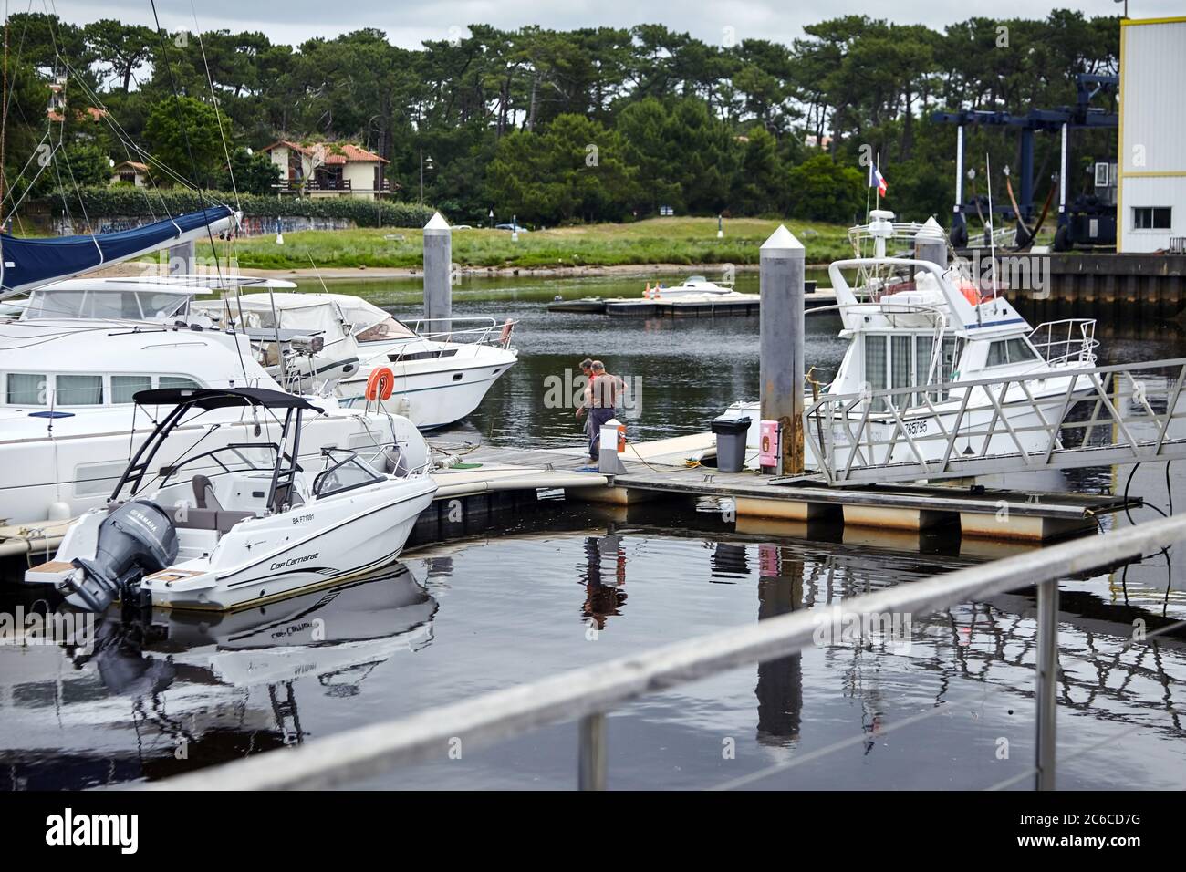 Capbreton, France - 19 juin 2018 : bateaux amarrés et portuaires. Des hommes sur la jetée près du bateau à moteur et des yachts de plaisance. Port sur la côte Atlantique sur une cl Banque D'Images