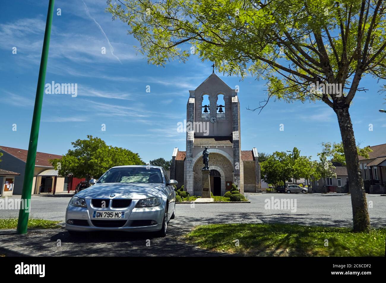 Saint-Maurice-les-Brousses, haute-Vienne, France - 23 juin 2018 : place de l'Église. Сhurch avec des cloches et le mémorial de guerre. Voiture garée à l'ombre o Banque D'Images