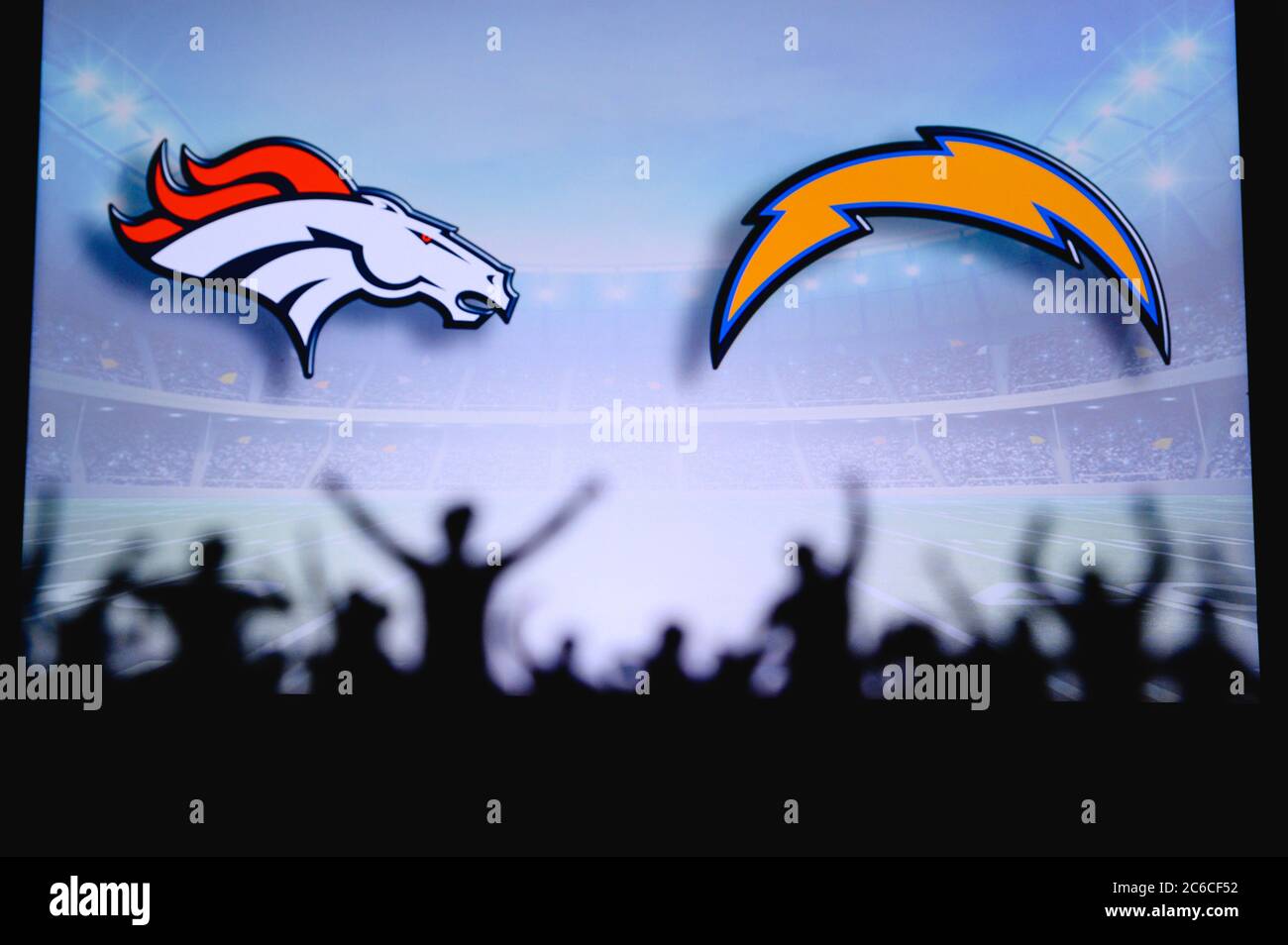 Denver Broncos contre Los Angeles Chargers. Assistance pour les fans sur NFL Game. Silhouette des supporters, grand écran avec deux rivaux en arrière-plan. Banque D'Images