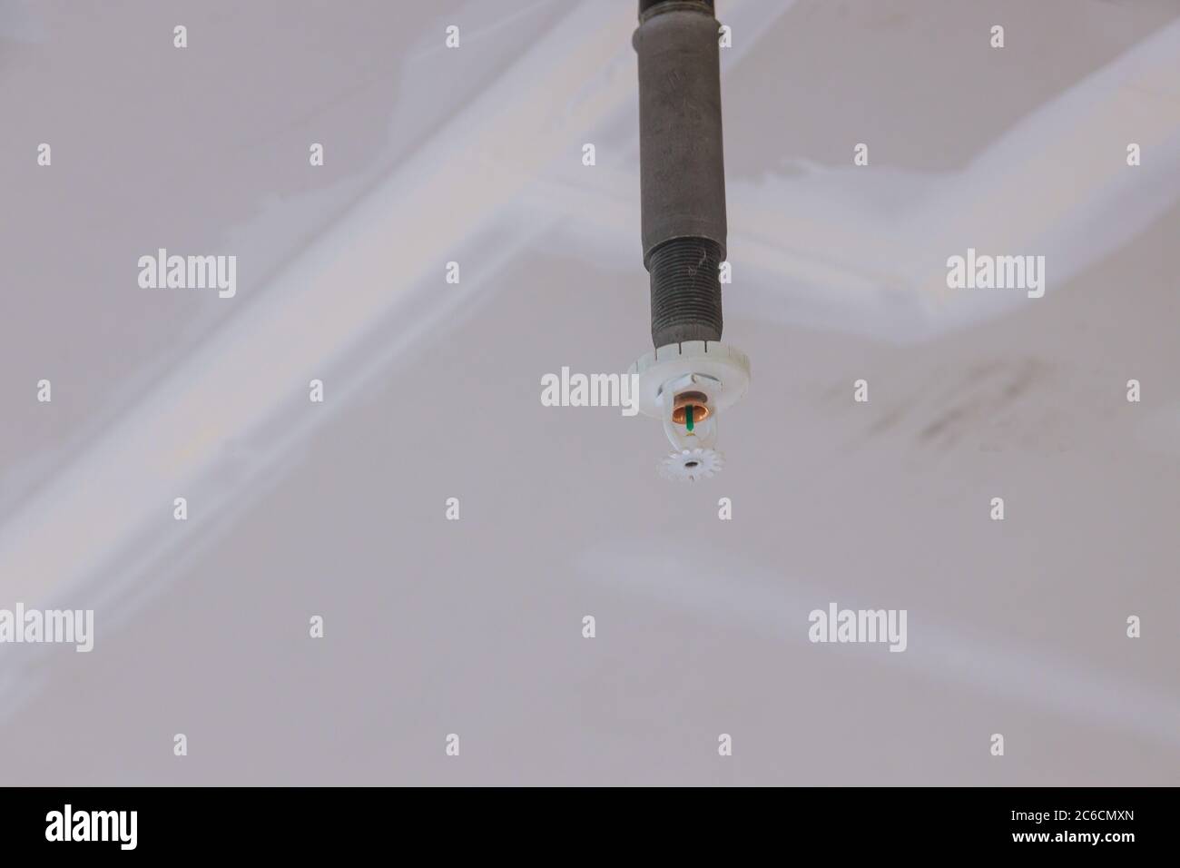 Le technicien installe une arroseur incendie automatique au plafond dans le bâtiment de bureaux Banque D'Images