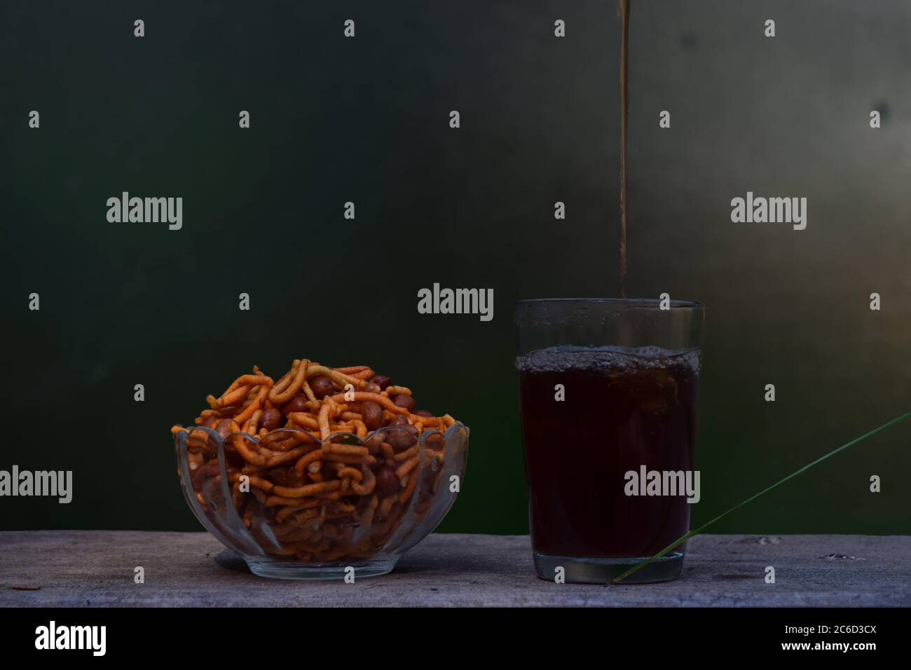 Thé noir versé dans un verre et un bol de mélange le jour des pluies Banque D'Images