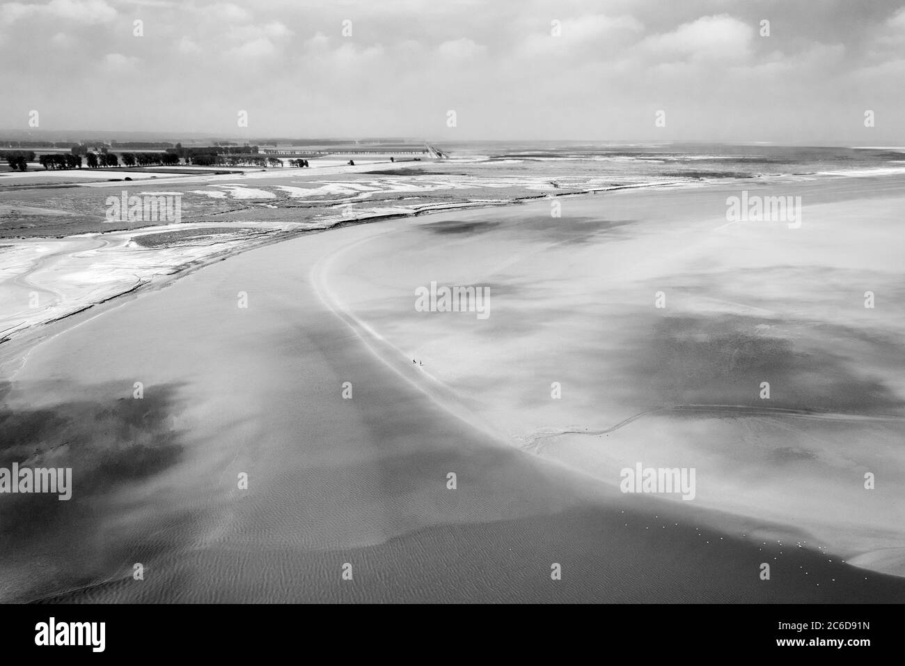 Paysage avec l'embouchure de la rivière vue du Mont Saint Michel et couple marchant à marée basse fond de l'océan loin. La liberté, la petite personne humaine dans le monde Banque D'Images