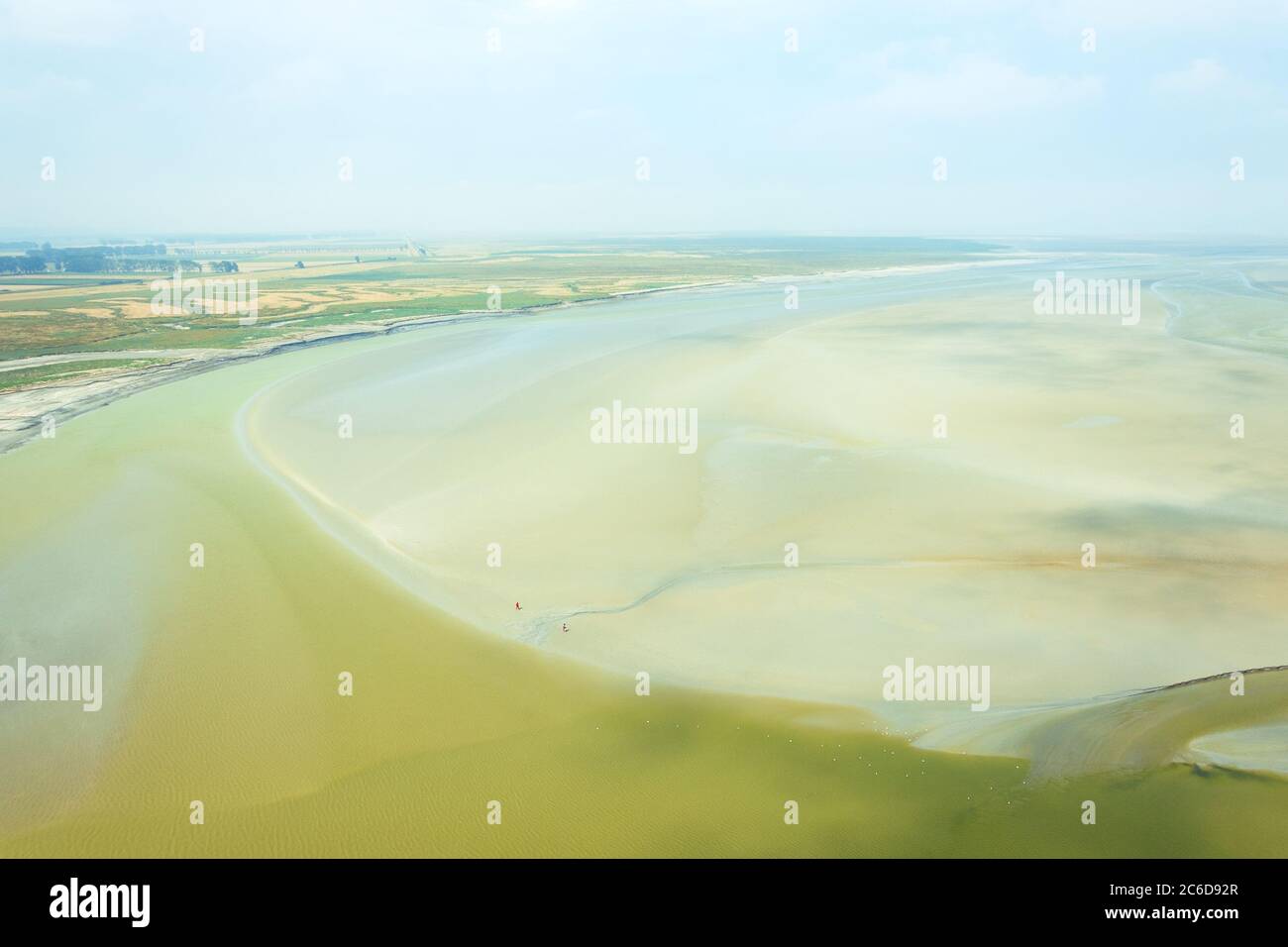 Paysage avec l'embouchure de la rivière vue du Mont Saint Michel et couple marchant à marée basse fond de l'océan loin. La liberté, la petite personne humaine dans le monde Banque D'Images
