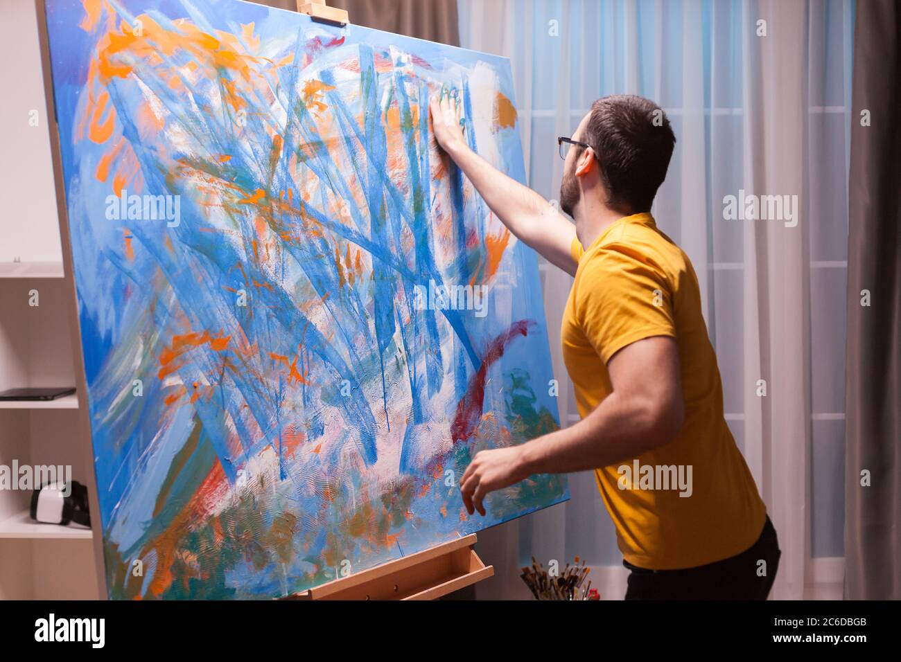 Technique de peinture à la main sur une grande toile en studio d'art. Peinture d'art moderne sur toile, création, contemporain et succès artiste de beaux-arts dessinant chef-d'œuvre Banque D'Images