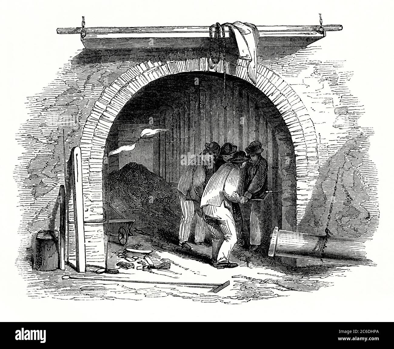 Une vieille gravure montrant des travailleurs dans une usine ou une usine de gaz, ici allumer le gaz - une illustration du début des années 1800. Le gaz de charbon a été introduit en Grande-Bretagne dans les années 1790 par l'inventeur écossais William Murdoch. Les premiers travaux de gaz ont été construits pour les usines de la Révolution industrielle et à partir d'environ 1805 comme source lumineuse. Les premières centrales à gaz étaient généralement situées à côté d'une rivière ou d'un canal, de sorte que le charbon pouvait être introduit par la barge. Le transport a ensuite été transféré vers les chemins de fer et la route. Banque D'Images