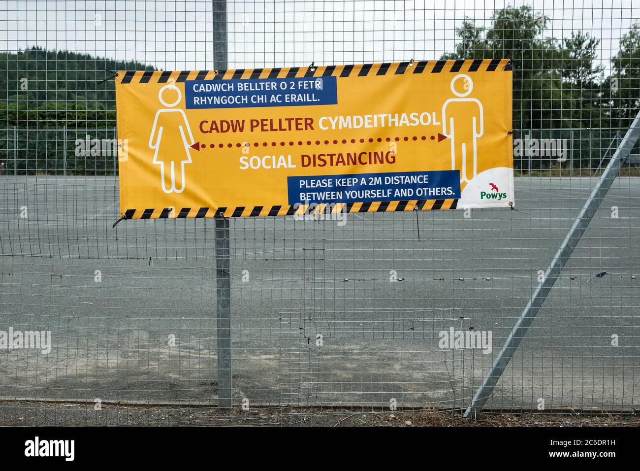 Un panneau devant le terrain de jeu de l'école John Beddoes, Presteigne, Powys, pays de Galles, Royaume-Uni, rappelant aux élèves la nécessité de prendre des distances sociales Banque D'Images