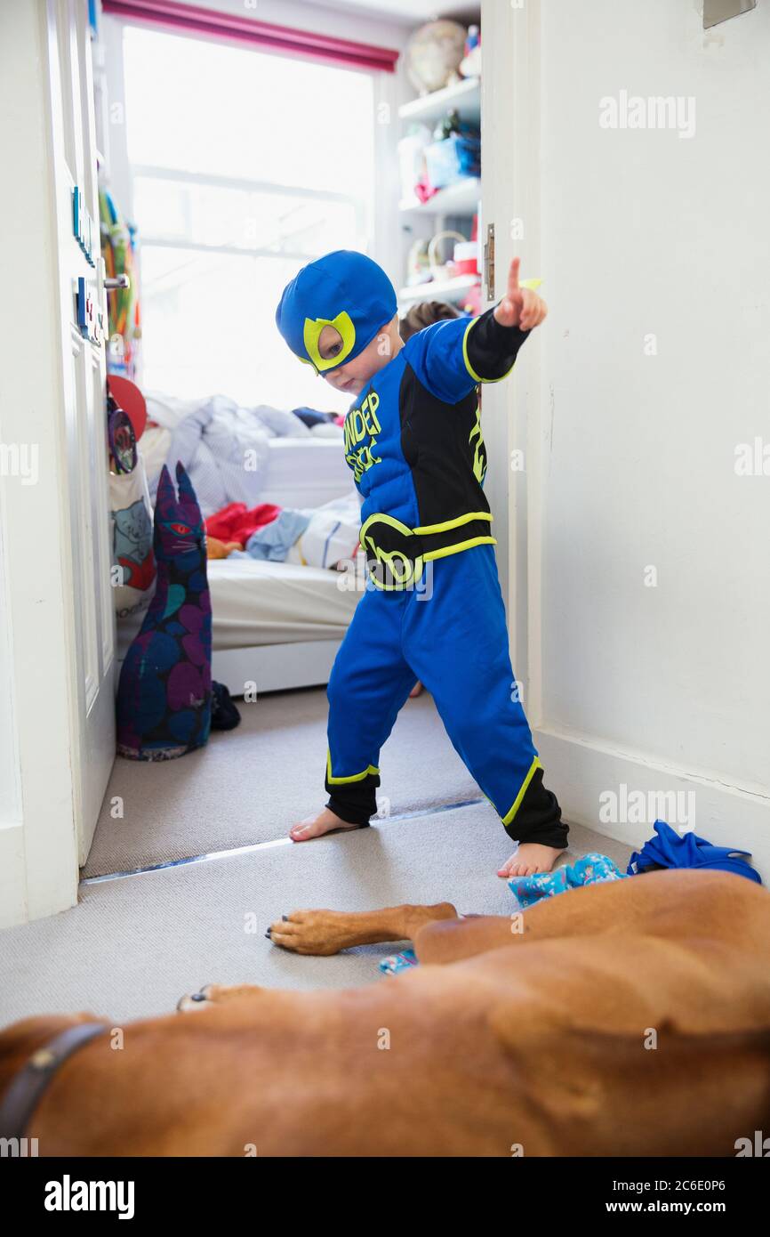 Garçon en costume de super-héros jouant à la maison Banque D'Images