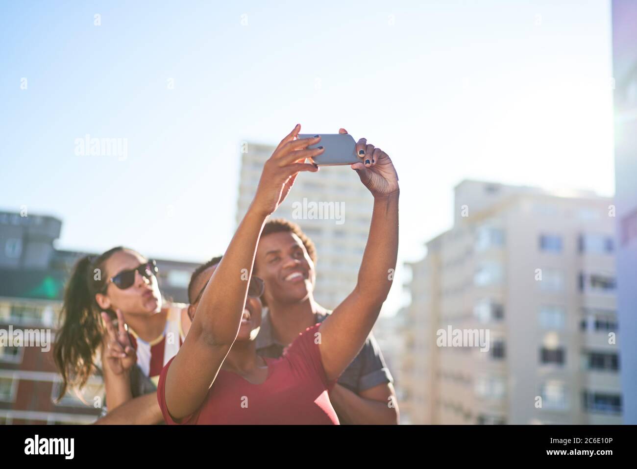 De jeunes amis prennent le selfie avec un smartphone sur un toit urbain ensoleillé Banque D'Images