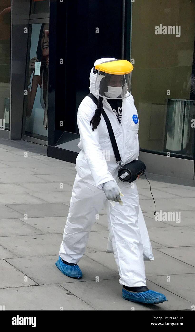 Les acheteurs du centre de Londres ce matin, deuxième journée de magasins non essentiels ouverte le 16 juin 2020, la pandémie mondiale de coronavirus Covid-19 de 2020 a forcé un confinement presque complet dans le monde entier. Au Royaume-Uni, les entreprises ont souffert gravement, avec trois mois de pertes dans tout le secteur. Ce n'est que maintenant que le verrouillage est levé avec prudence et que certaines entreprises tentent lentement de se reconstruire. Un piéton, ou un travailleur de la santé, descend la rue vêtu de son équipement de protection individuelle. Photo prise le 16 juin 2020 Banque D'Images