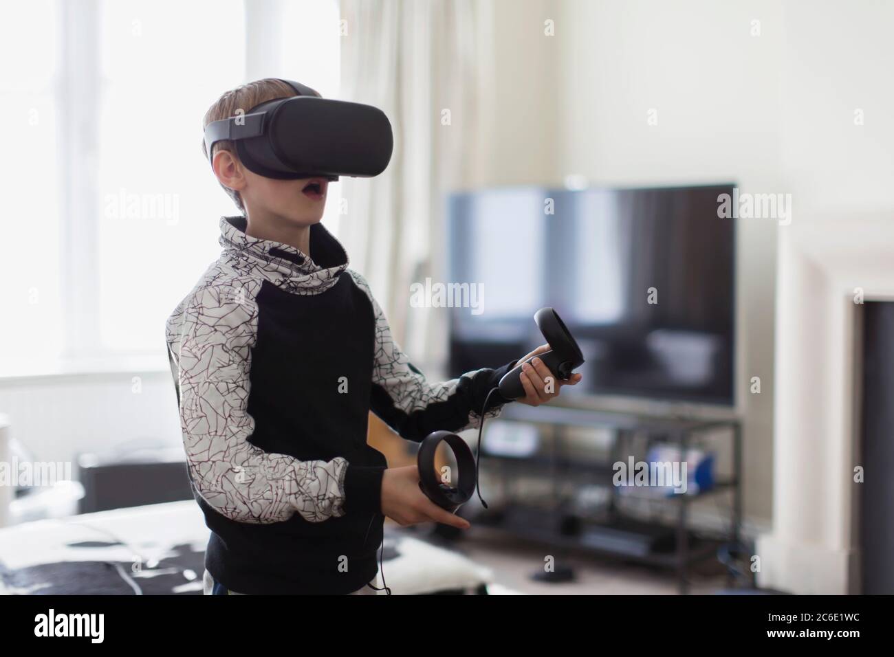 Garçon jouant à un jeu vidéo avec des lunettes VRS Banque D'Images