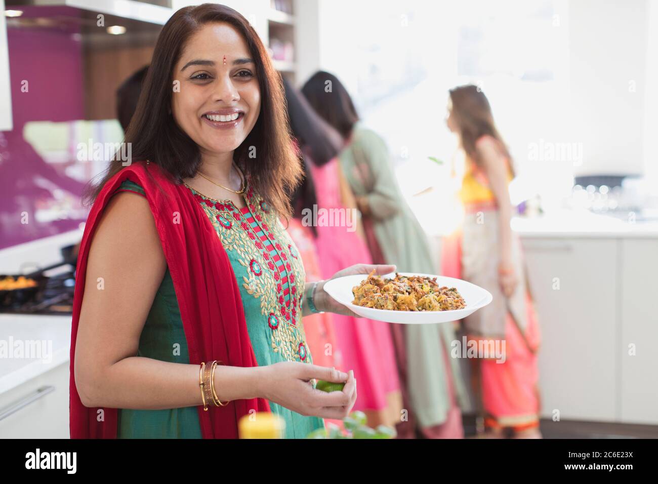 Portrait bonne femme indienne à sari manger dans la cuisine Banque D'Images