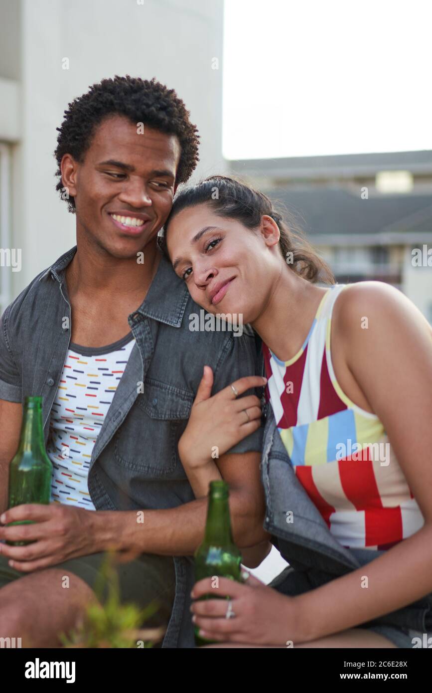 De jeunes amis heureux buvant de la bière sur le patio Banque D'Images