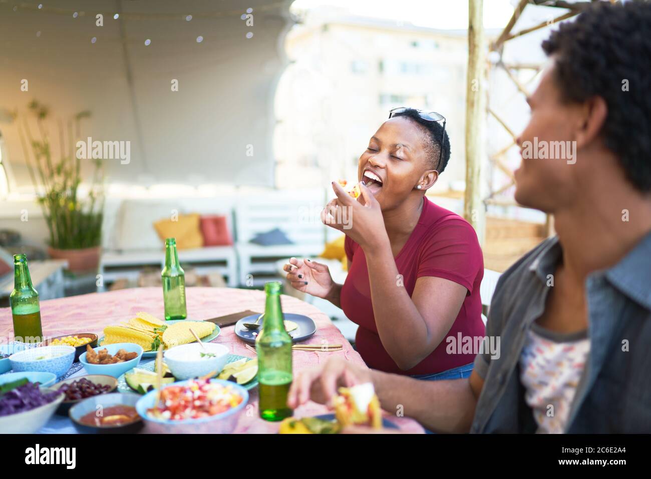 Jeune femme prenant un déjeuner à tacos à table de patio Banque D'Images