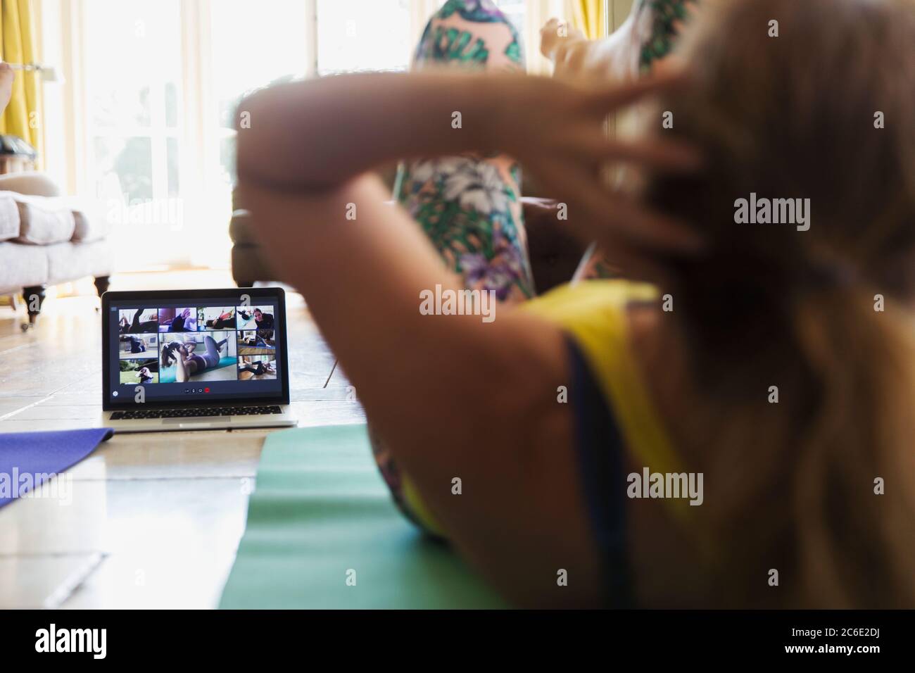 Femme s'exerçant en ligne avec un ordinateur portable à la maison Banque D'Images