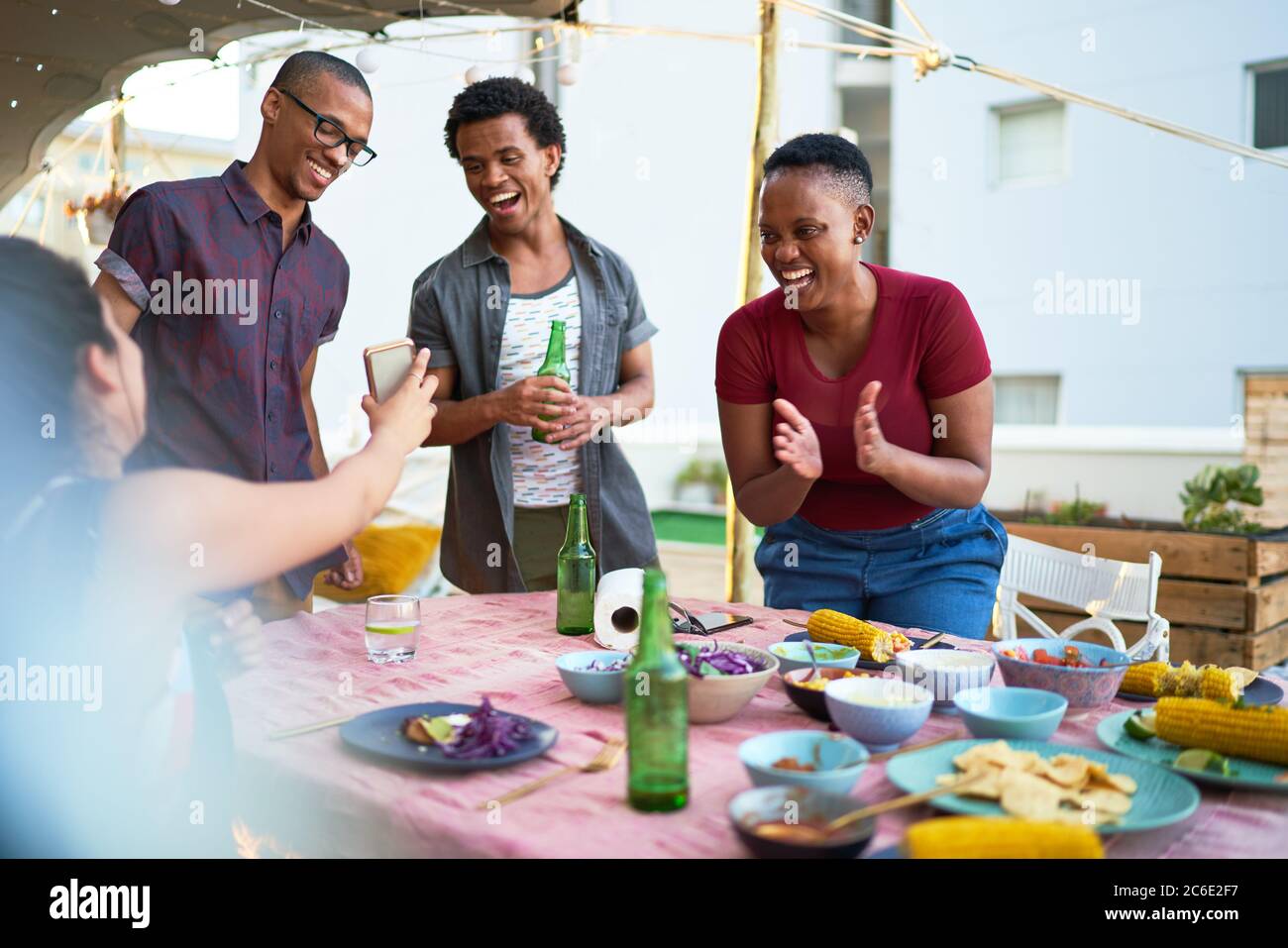 De jeunes amis heureux de déjeuner à table de patio Banque D'Images