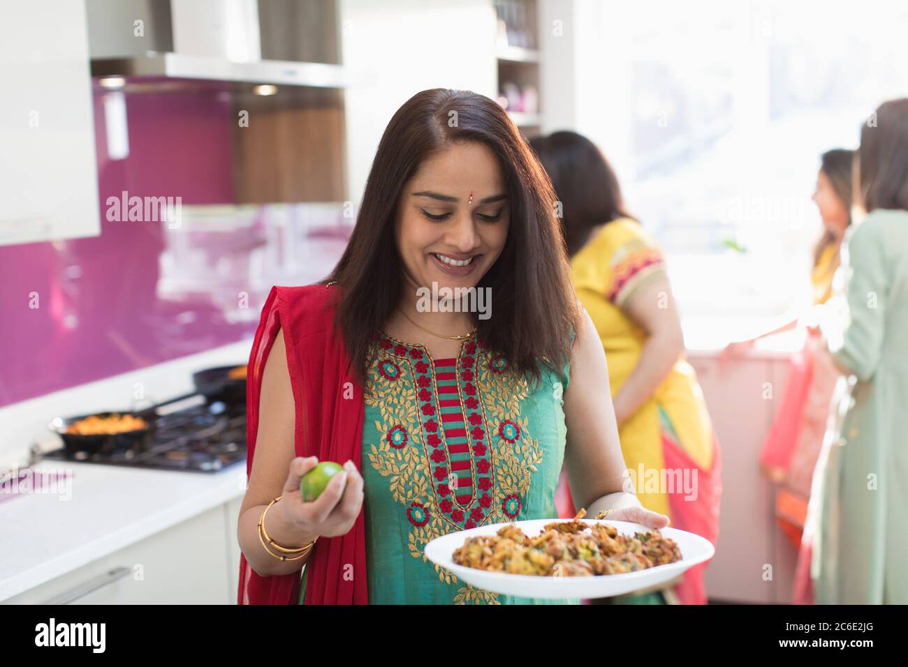Femme indienne à sari avec assiette de nourriture dans la cuisine Banque D'Images