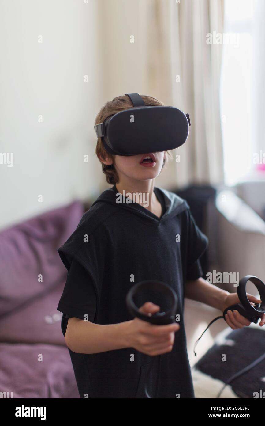 Garçon jouant à un jeu vidéo avec des lunettes VRS Banque D'Images