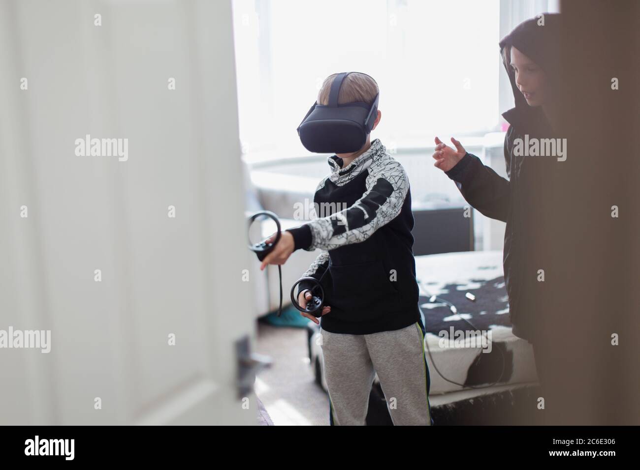 Frères jouant à un jeu vidéo avec des lunettes VRS Banque D'Images Frères jouant à un jeu vidéo avec des lunettes VRS Banque D'Images