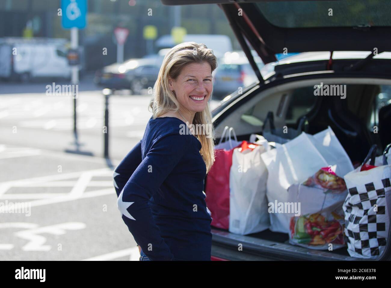 Portrait bonne femme avec sacs d'épicerie dans le sac de voiture Banque D'Images