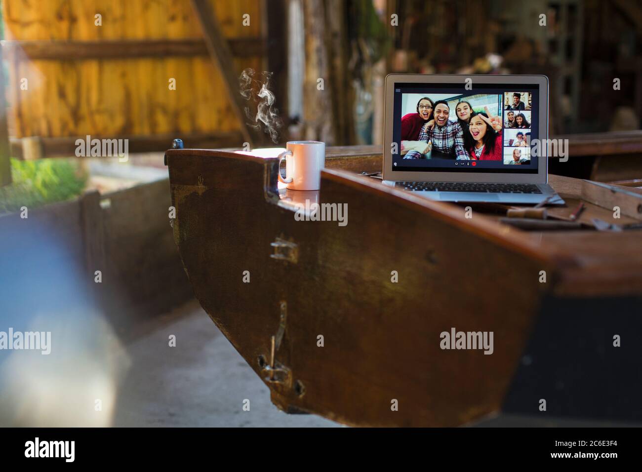 Amis discutant vidéo sur écran d'ordinateur portable sur bateau en bois Banque D'Images