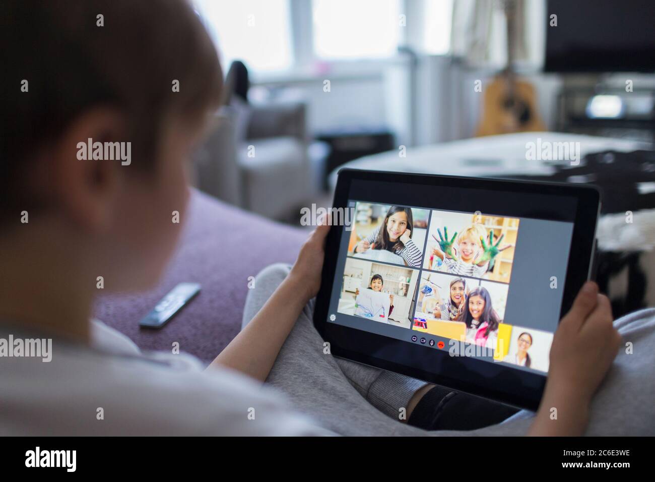 Garçon avec tablette numérique e-learning sur le canapé Banque D'Images