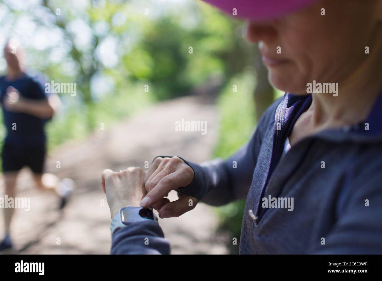 Jogging féminin avec montre intelligente sur la piste Banque D'Images