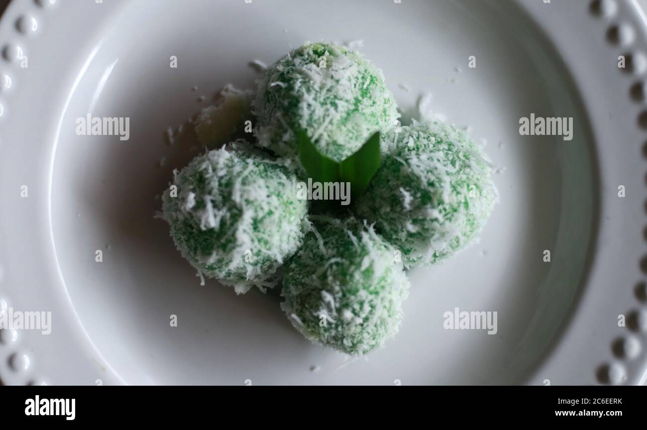 Klepon. Boulettes de riz pandanus traditionnelles faites de farine gluante et de noix de coco râpées avec garniture de sucre de palme. Cuisine traditionnelle indonésienne. Banque D'Images