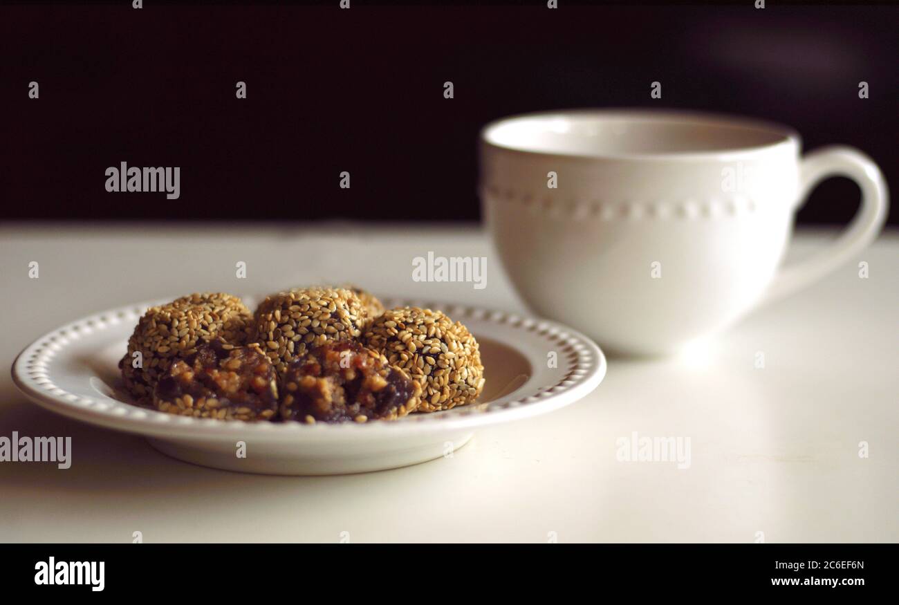 Boulettes de graines de sésame ou Onde-onde et une tasse de boisson. Farine de riz gluante farcie de pâte de haricots mung enrobée de graines de sésame. Indonésien traditionnel Banque D'Images