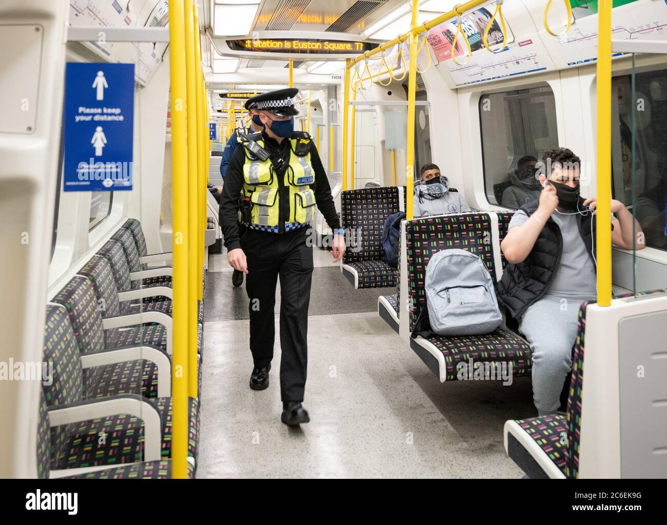 Les navetteurs portant des masques sur le métro de Londres . British transport police sur la Metropolitan Line, vérifier que les gens portent tous des masques. Juillet 6 Banque D'Images