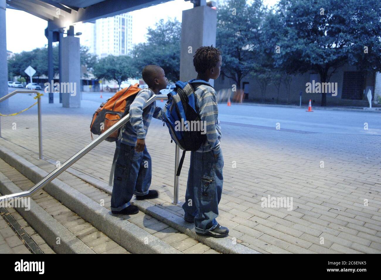 Austin, Texas États-Unis, 14 septembre 2005 : les frères Elliott (à droite) et Ashton Williams (à gauche) se tiennent devant le Austin Convention Center, qui abrite des centaines de Louisiane évacués de l’ouragan Katrina, attendant qu’un autobus scolaire les emmène à l’école primaire. Les garçons font partie des plus de 500 écoliers évacués inscrits dans les écoles publiques d'Austin cette semaine. ©Bob Daemmrich Banque D'Images