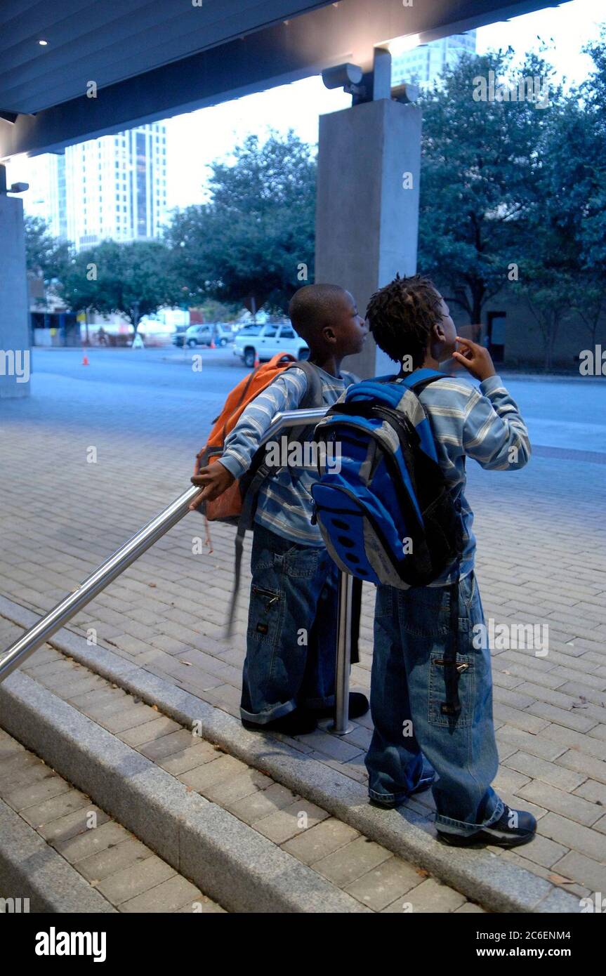 Austin, Texas États-Unis, 14 septembre 2005 : les frères Elliott (à droite) et Ashton Williams (à gauche) se tiennent devant le Austin Convention Center, qui abrite des centaines de Louisiane évacués de l’ouragan Katrina, attendant qu’un autobus scolaire les emmène à l’école primaire. Les garçons font partie des plus de 500 écoliers évacués inscrits dans les écoles publiques d'Austin cette semaine. ©Bob Daemmrich Banque D'Images