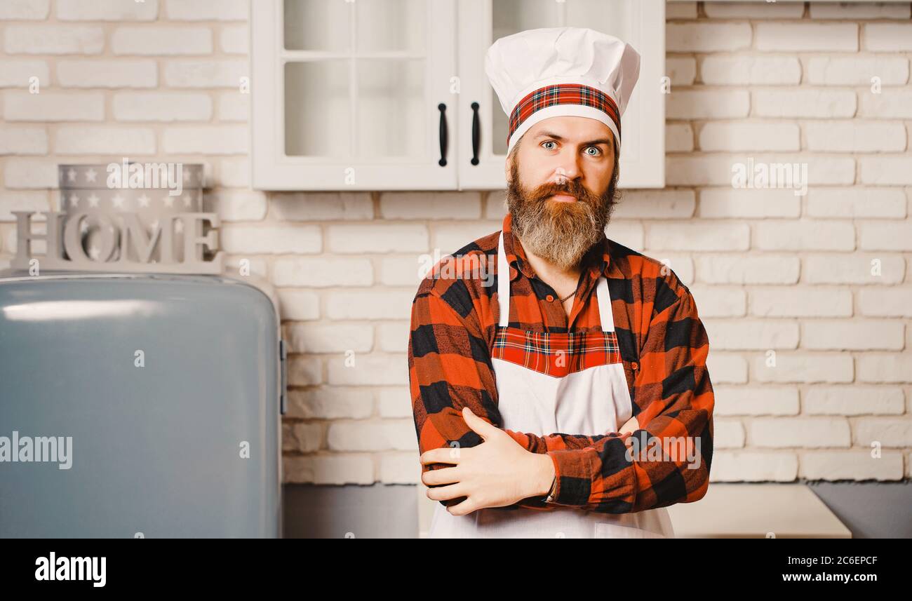 Un jeune barbu, habillé d'une chemise rouge et d'un tablier blanc. Banque D'Images