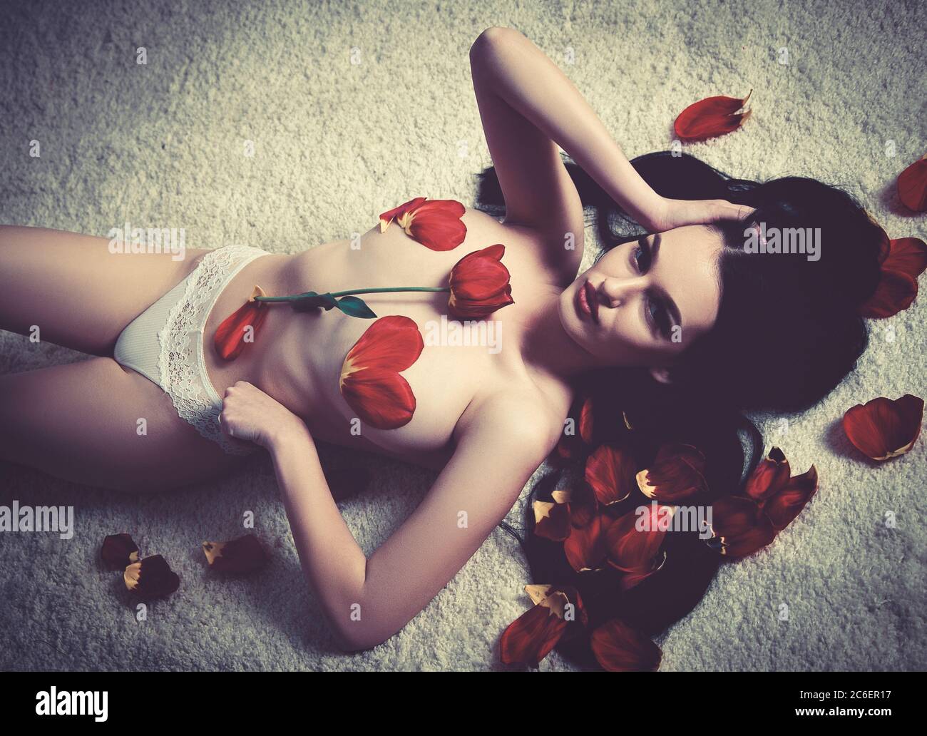 Sexy dame, brunette modèle de mode avec art de la forme du corps en tulipes fleurs et pétales. Banque D'Images