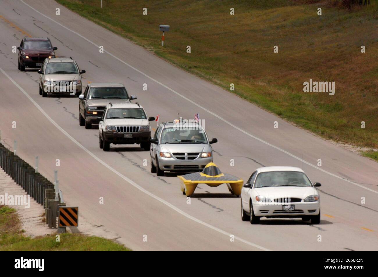 Weatherford, Texas 18 juillet 2005 : voiture solaire de l'Université Western Michigan prise en sandwich entre des véhicules à combustion interne alimentés par des combustibles fossiles sur une autoroute lors de la première journée de la course de voitures solaires de 2 500 miles du North American Solar Challenge d'Austin, Texas à Calgary, Alberta Canada. L'événement de 10 jours met en vedette 22 équipes collégiales et universitaires des États-Unis et du Canada. ©Bob Daemmrich Banque D'Images