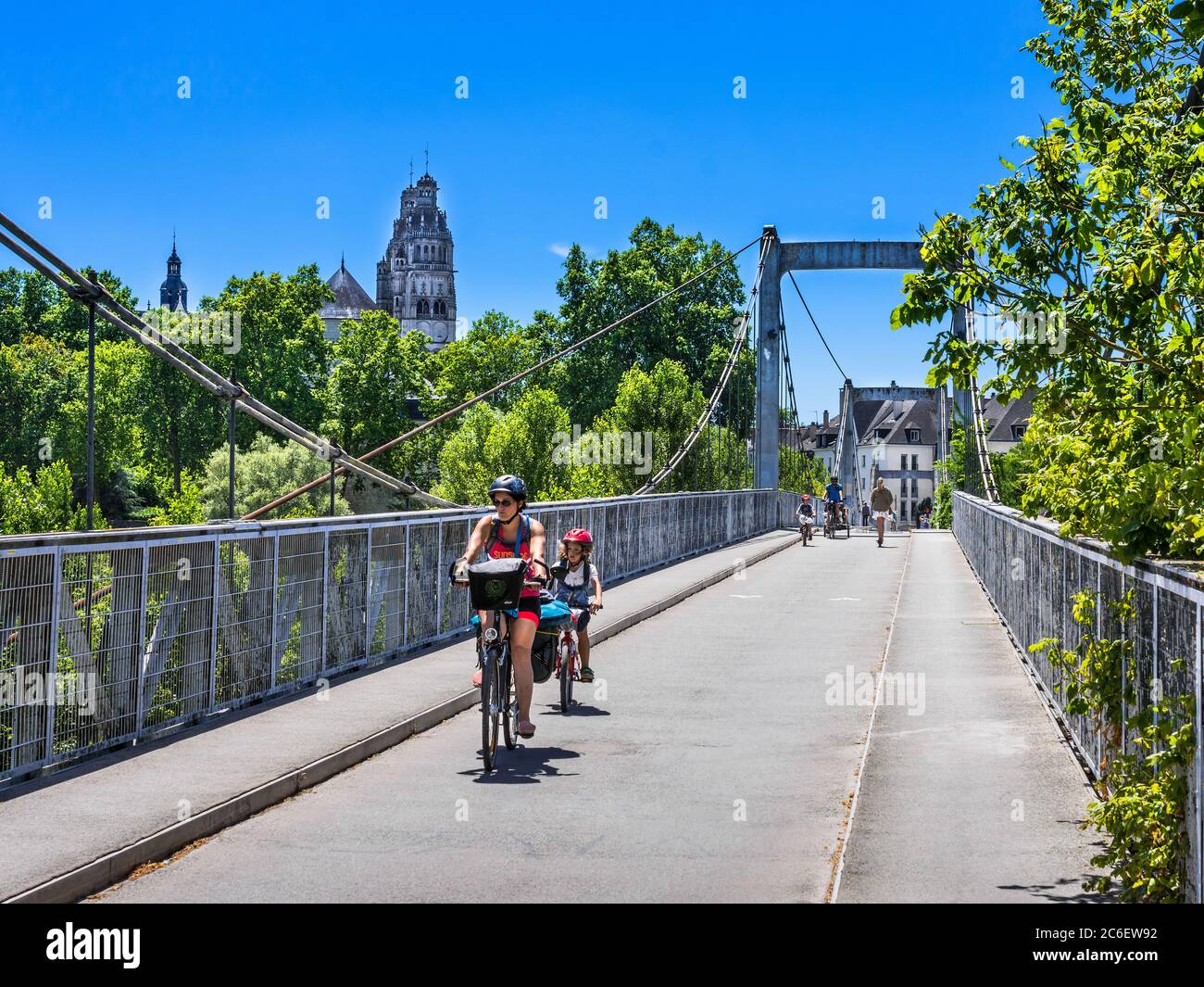 Famille sur bicyclettes traversant le pont suspendu étroit sur la Loire, Tours, Indre-et-Loire, France. Banque D'Images