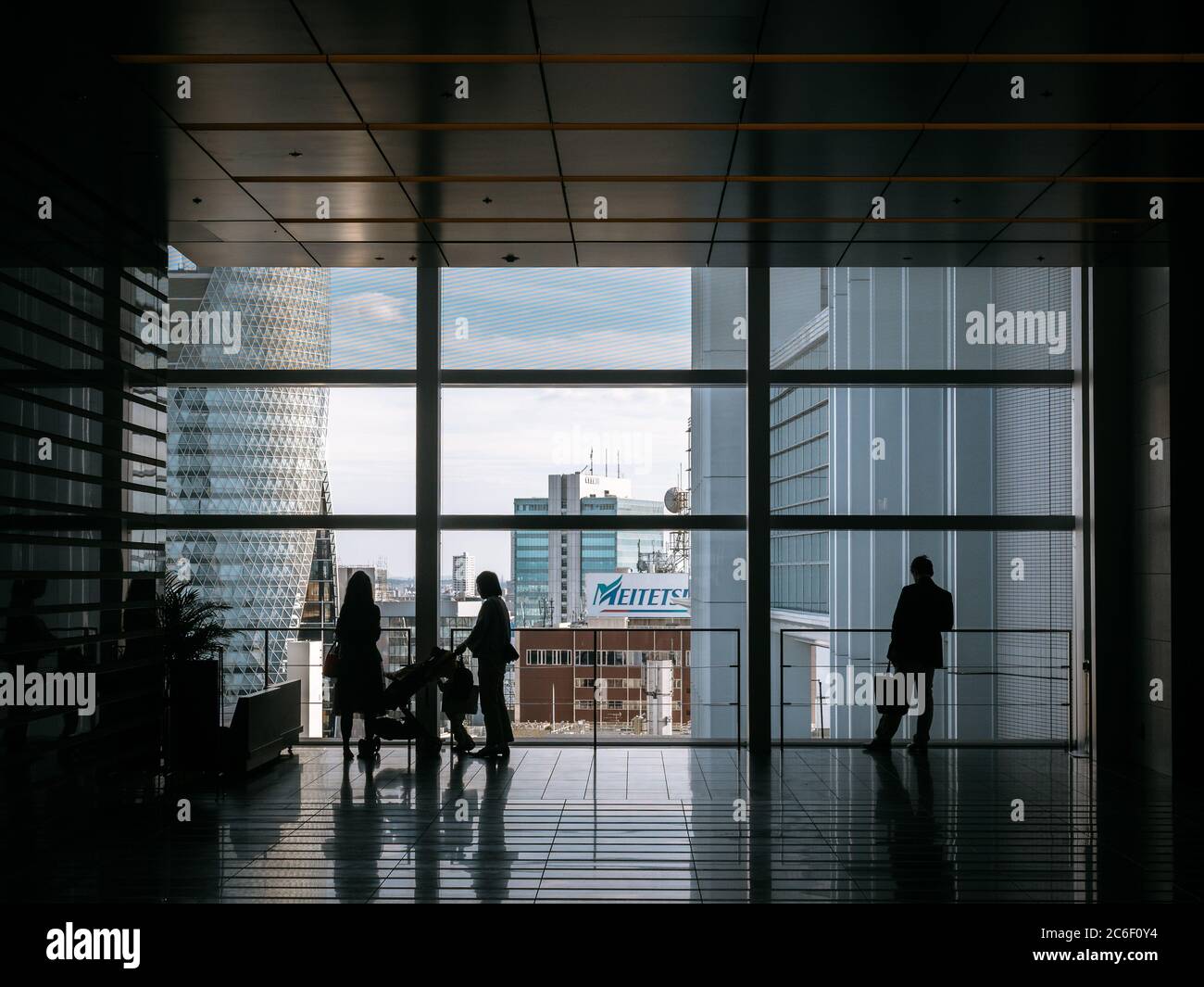 Nagoya, Aichi, Japon - Cityscape depuis la gare de Nagoya. Vue sur le centre-ville. Silhouette de personnes qui regardent la fenêtre. Bâtiment en spirale. Gratte-ciel. Banque D'Images