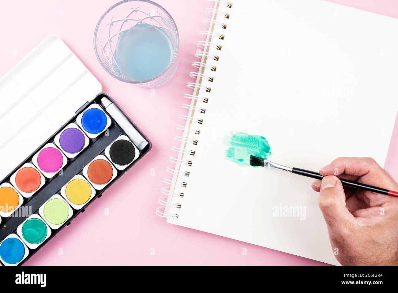 peinture avec aquarelles, vue de dessus de la boîte de peinture, bloc d'esquisse et personne utilisant le pinceau Banque D'Images