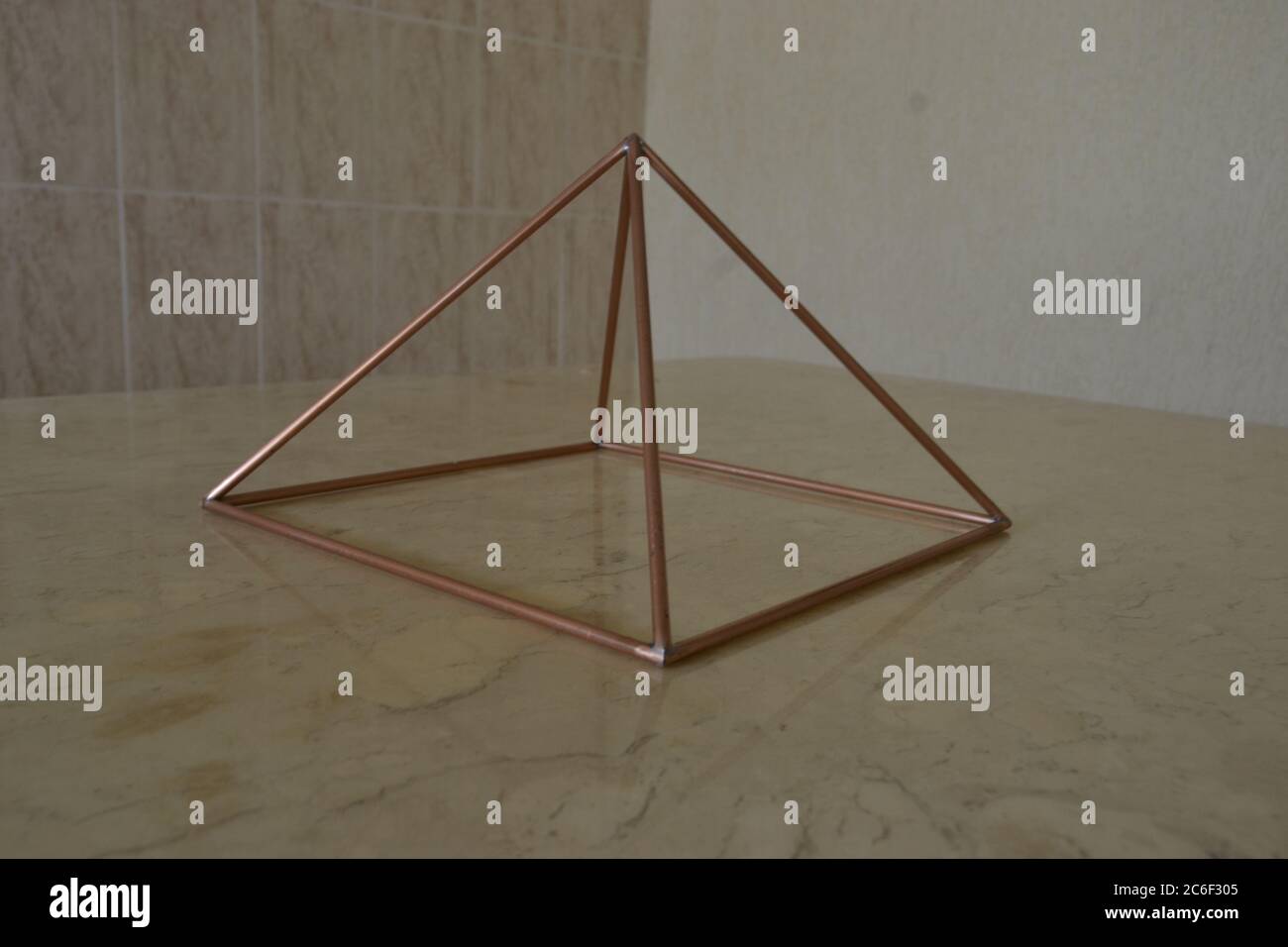 Pyramide de cuivre, vue latérale, sur une base en marbre travertin et un fond de carreaux de céramique, Brésil, Amérique du Sud Banque D'Images