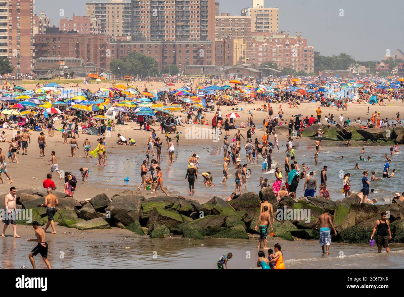 Des milliers de personnes en bord de mer observent généralement des distances sociales en essayant de combattre la chaleur et l'humidité à Coney Island à Brooklyn, New York, le long week-end de l'indépendance Day, le dimanche 5 juillet 2019. (© Richard B. Levine) Banque D'Images