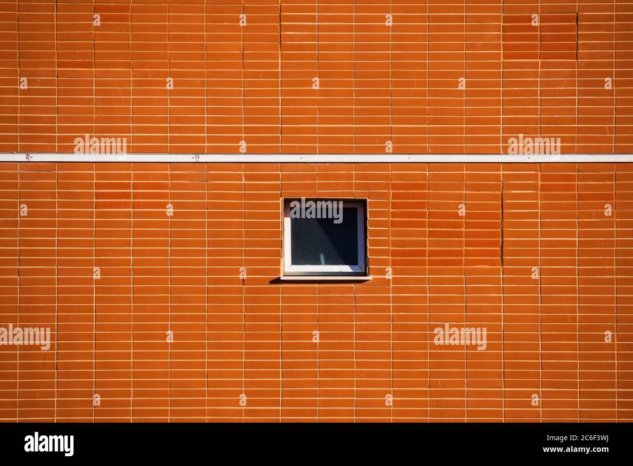 Façade d'un bâtiment avec un rectangle orange briques motif, une ligne blanche et une fenêtre centrée. Banque D'Images
