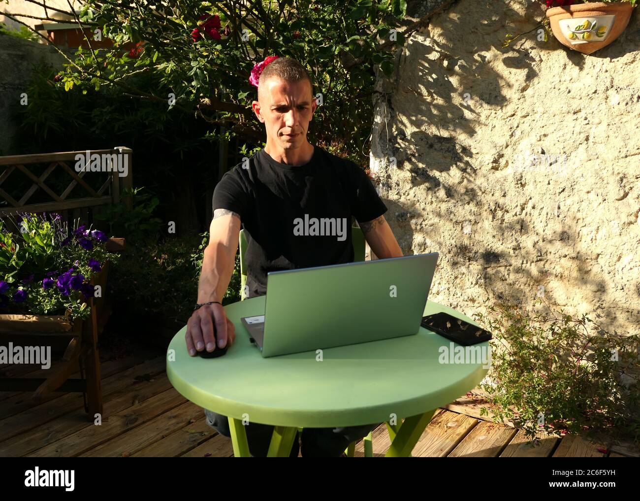 Homme travaillant sur un ordinateur portable à la maison dans son jardin. Travaillez pour la distanciation sociale. Achats en ligne avec Internet. Quelqu'un qui est énervé, fatigué, respirant. Banque D'Images