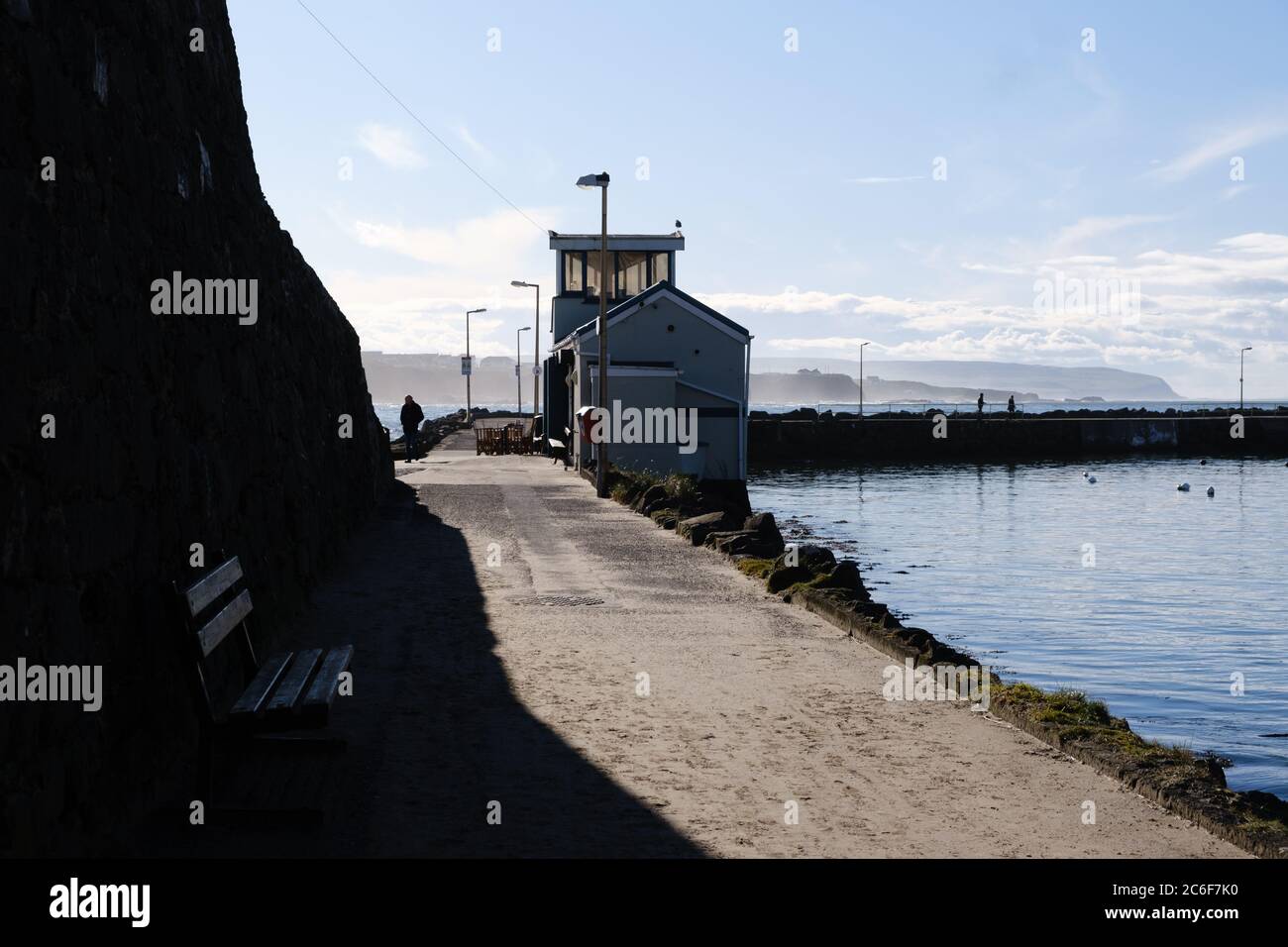 Scène éthérée au port de Portrush à Co. Antrim, en Irlande du Nord, un homme marche vers des ombres sombres Banque D'Images
