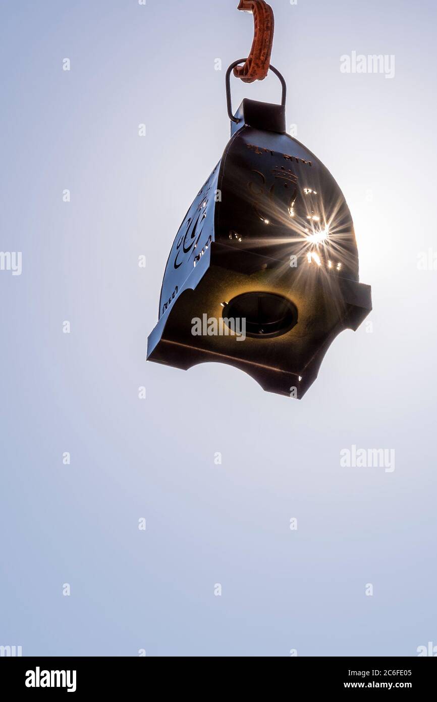 Une lanterne noire suspendue dans l'air est frappée par les rayons du soleil qui sont allumés. Banque D'Images