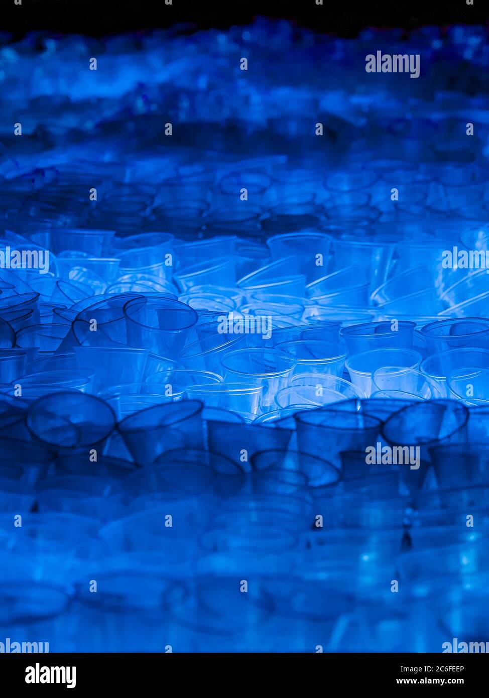 tas énorme de jetés utilisé transparent jetable tasses en plastique illuminé par la lumière bleue, pollution de l'environnement Banque D'Images