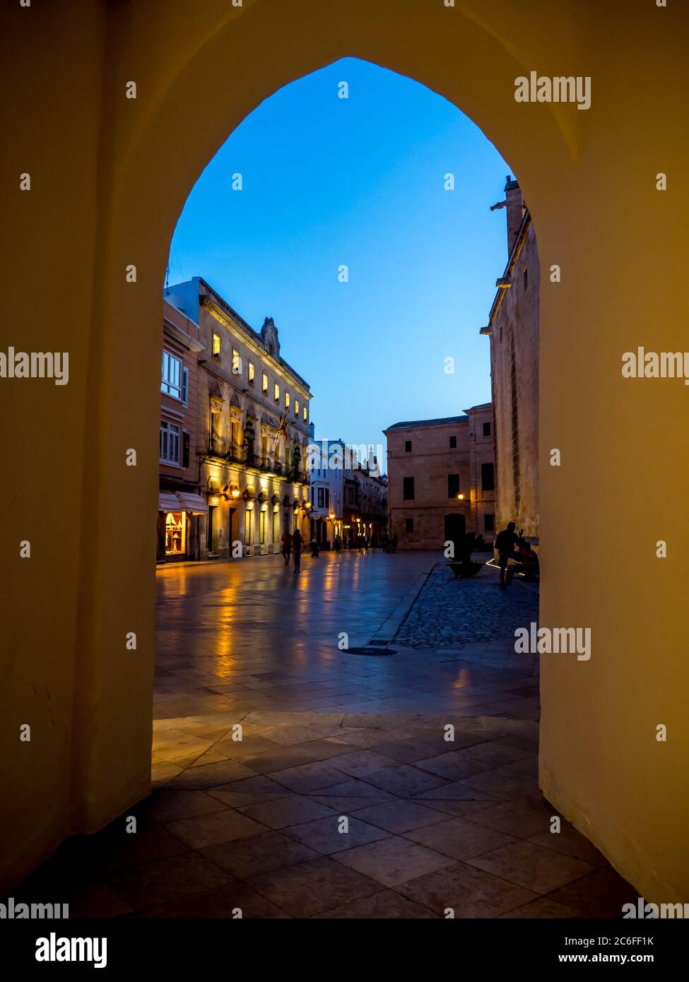Vue pittoresque et lumineuse au crépuscule à travers une arcade jusqu'à la Plaça de la Catedral à proximité du consell insular de menorca à ciutadella Banque D'Images