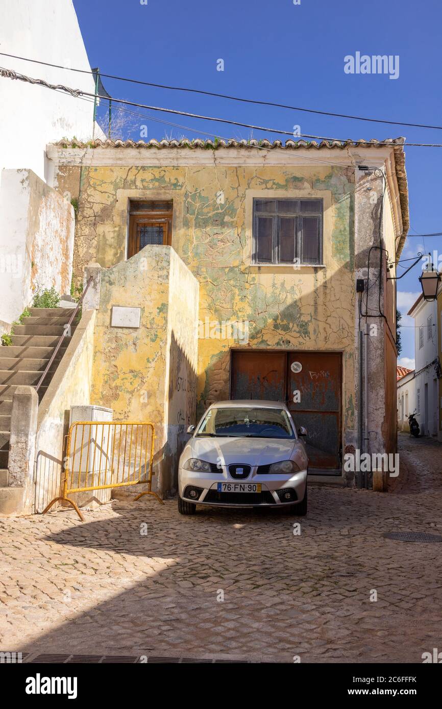 Rue latérale résidentielle avec peinture de peinture de la vieille maison et voiture garée en face dans le centre-ville de Silves Portugal Banque D'Images